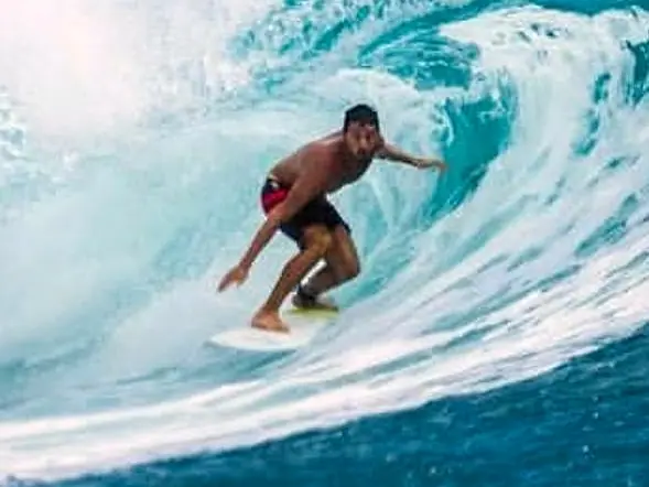Surfista dentro de um tubo numa onda azul-turquesa